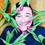 Gezicht van Loekie, liggend op de grond bezaaid met tulpen